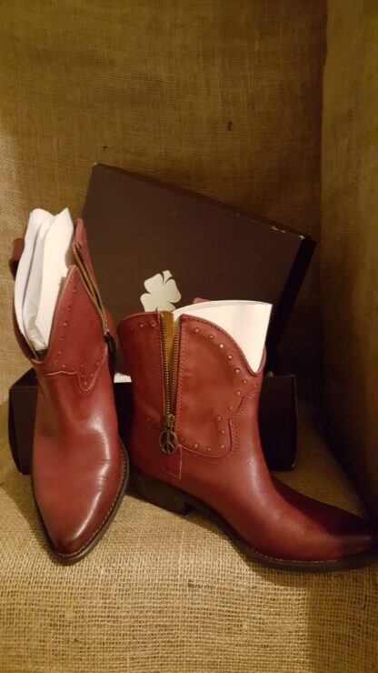 A pair of boots sitting next to a purse.