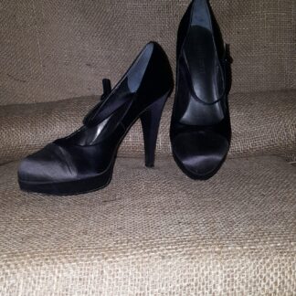 A pair of black shoes sitting on top of a couch.