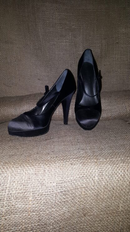 A pair of black shoes sitting on top of a couch.