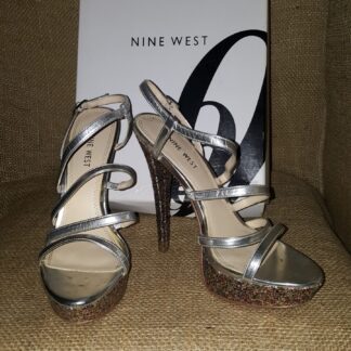 A pair of silver shoes sitting on top of a box.