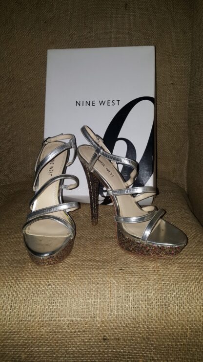 A pair of silver shoes sitting on top of a box.