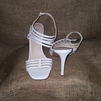 A pair of white shoes sitting on top of a brown chair.