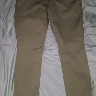 A pair of khaki pants sitting on top of a bed.