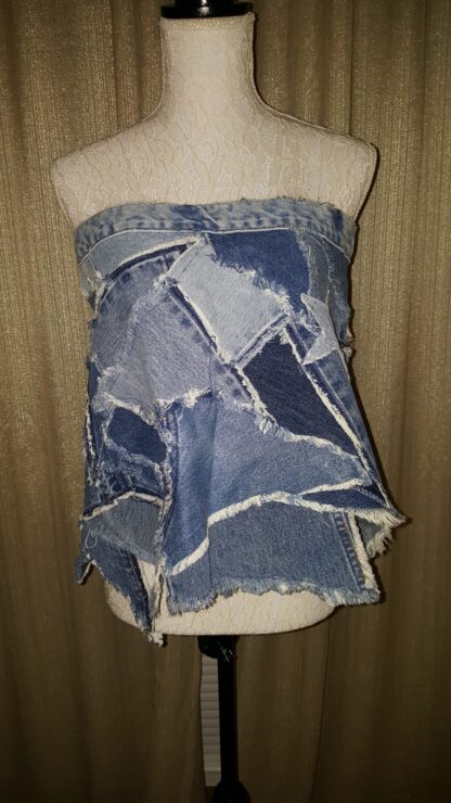 A woman 's torso is covered with jeans and patchwork.