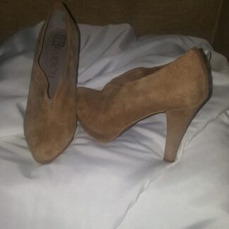 A pair of brown shoes on top of a white blanket.