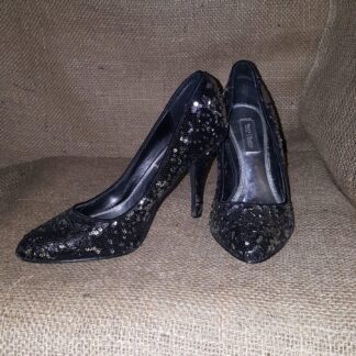 A pair of black shoes sitting on top of a couch.