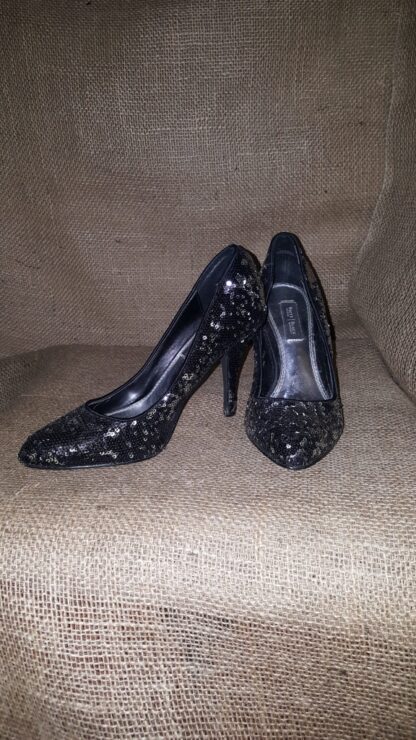A pair of black shoes sitting on top of a couch.