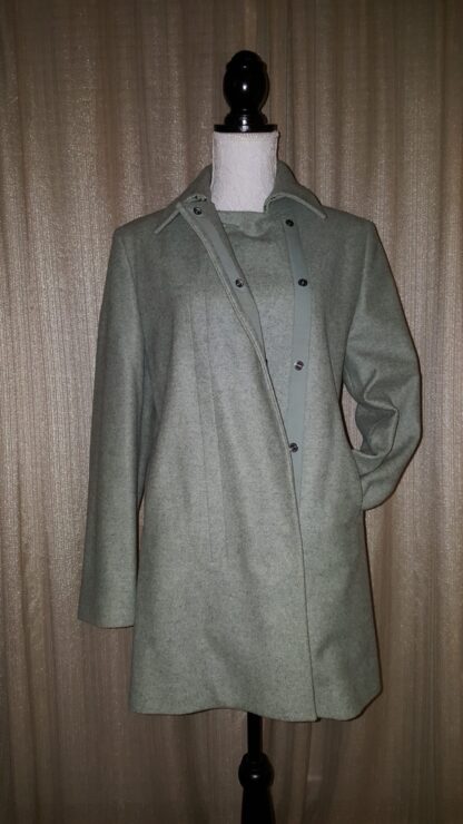 A coat is shown on display against the wall.