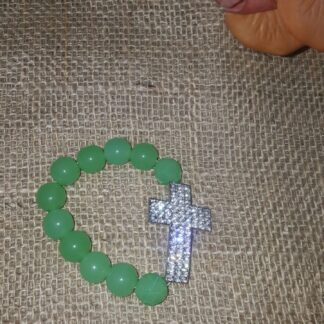A green bead bracelet with a silver cross on it.
