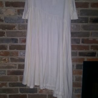 A white dress hanging up against the wall.