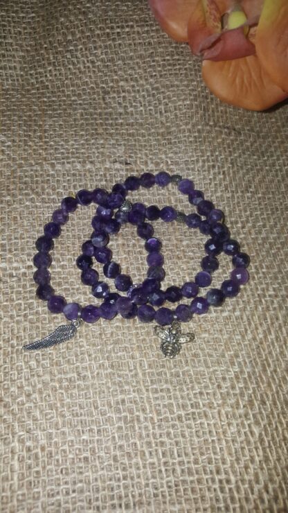 A purple bead necklace with a cross charm.