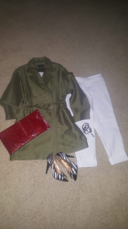 A green jacket, white pants and red purse.