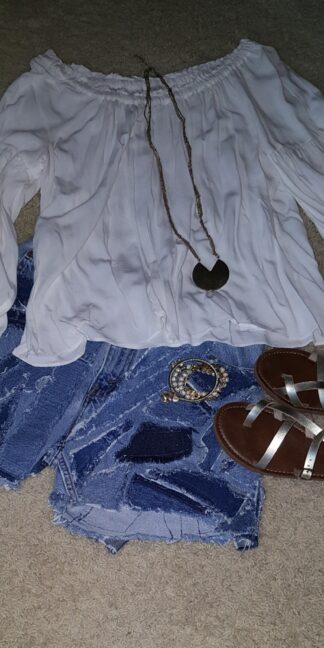 A white top and sandals are laid out on the floor.