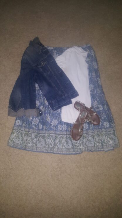 A blue dress with jeans and brown shoes on the floor