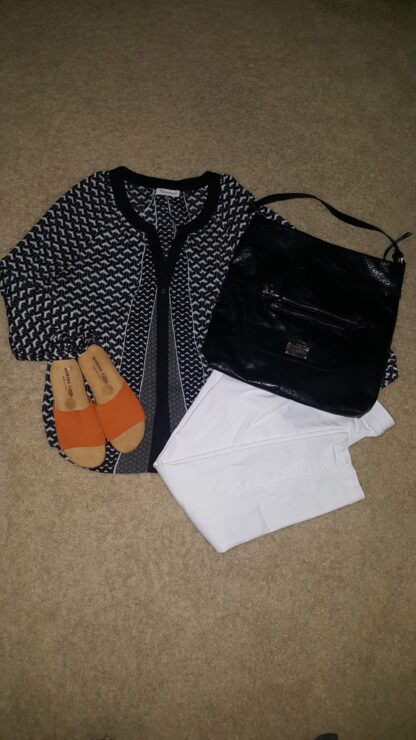 A black and white outfit with orange sandals
