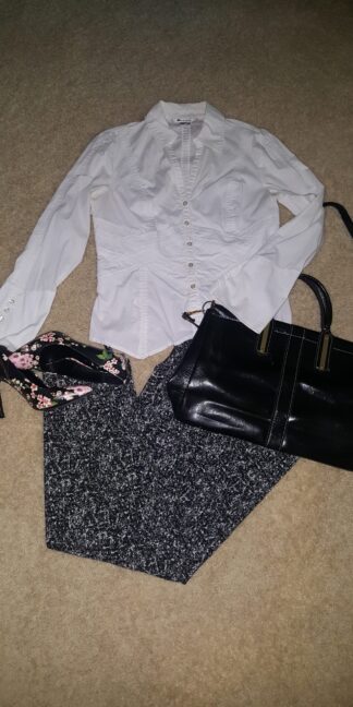 A white shirt and black purse on the floor