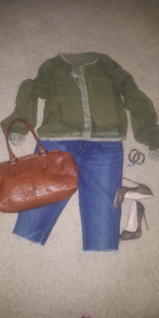 A woman 's outfit including jeans, jacket and purse.