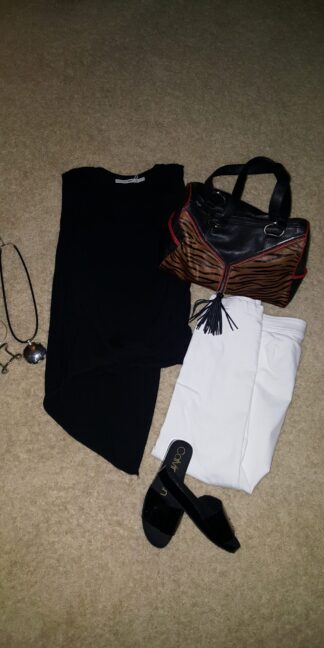 A purse, sunglasses and a pair of shoes laid out on the floor.