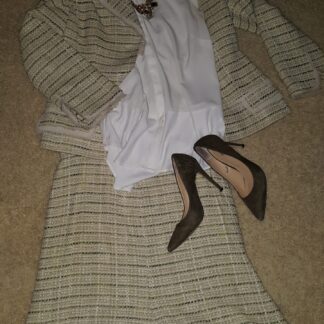 A woman 's dress and shoes laid out on the floor.