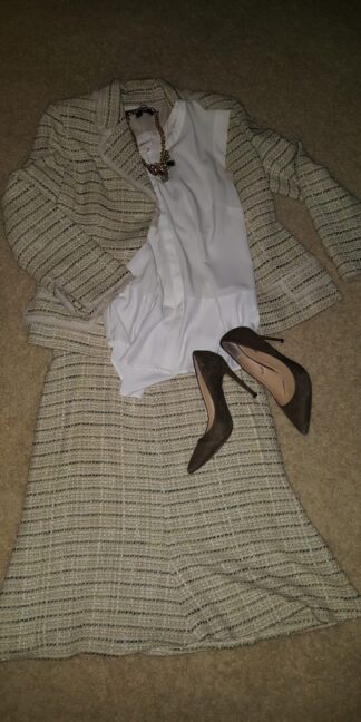 A woman 's dress and shoes laid out on the floor.