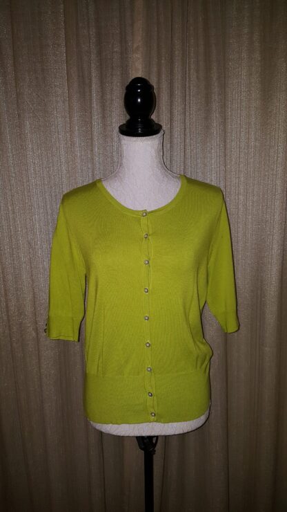 A lime green cardigan is shown on display.